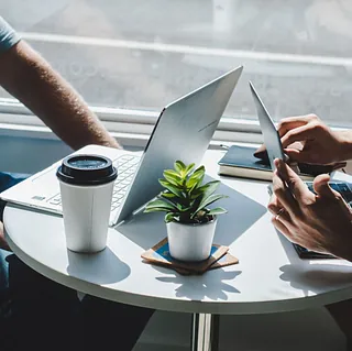 To personer med laptop på lite bord